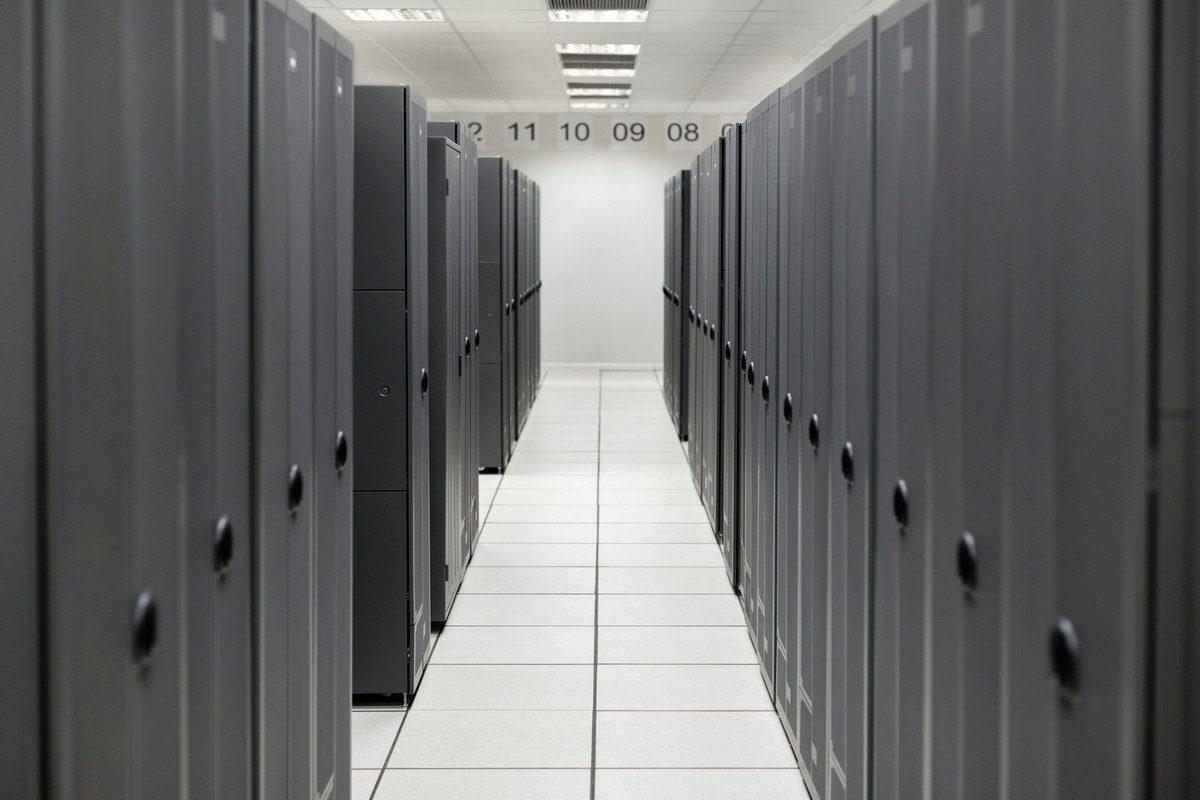 JFM Technology A data center aisle with tall gray server racks on both sides